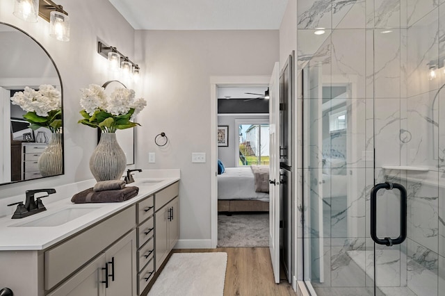 bathroom with hardwood / wood-style floors, vanity, an enclosed shower, and ceiling fan