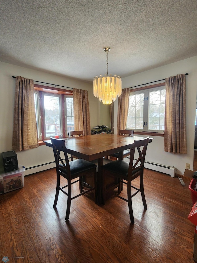 dining space with a textured ceiling, hardwood / wood-style floors, a notable chandelier, and baseboard heating