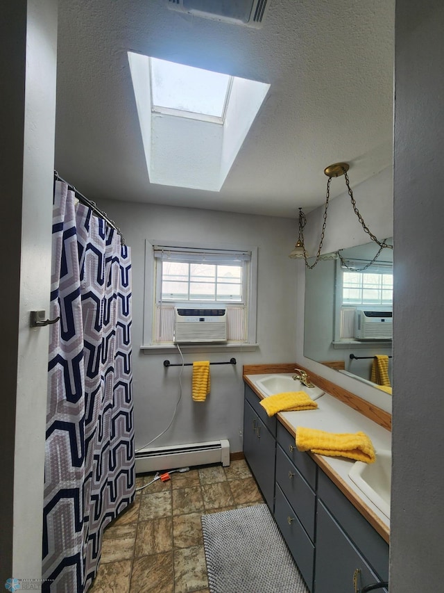 bathroom with baseboard heating, vanity, a skylight, and cooling unit