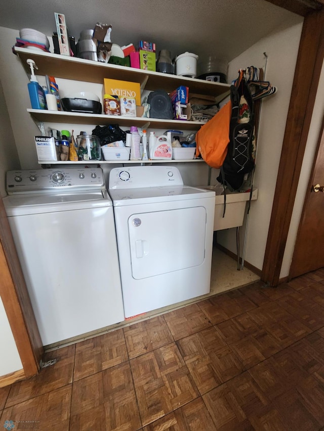 laundry area with dark parquet flooring and independent washer and dryer