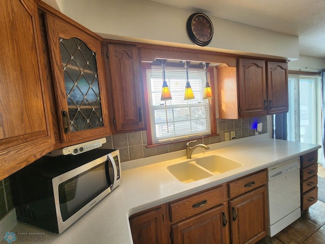 kitchen featuring white dishwasher, sink, and decorative backsplash