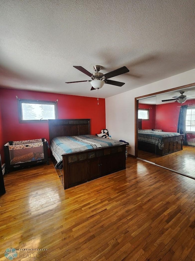 bedroom featuring ceiling fan, hardwood / wood-style floors, and a textured ceiling