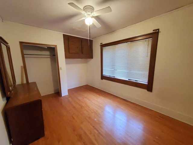 unfurnished bedroom featuring a closet, light hardwood / wood-style flooring, and ceiling fan