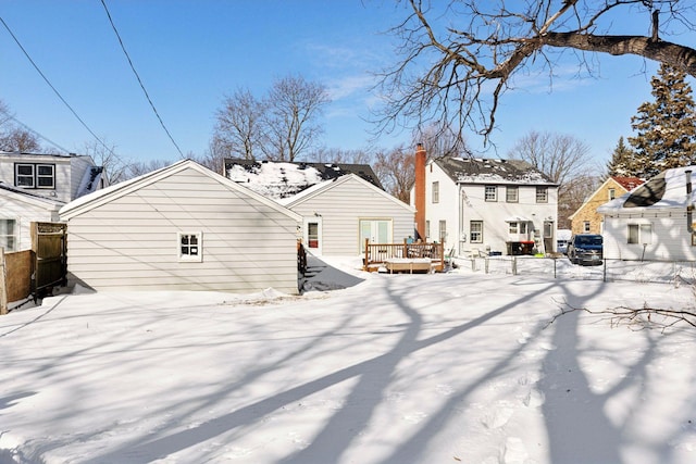 snow covered house with a wooden deck