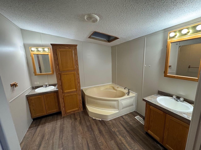 66156 County Road 132, Northome, MN 56661 - bathroom featuring a textured ceiling, vanity, wood-type flooring, and a tub