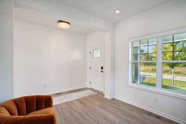 entryway featuring hardwood / wood-style floors, a notable chandelier, and a wealth of natural light