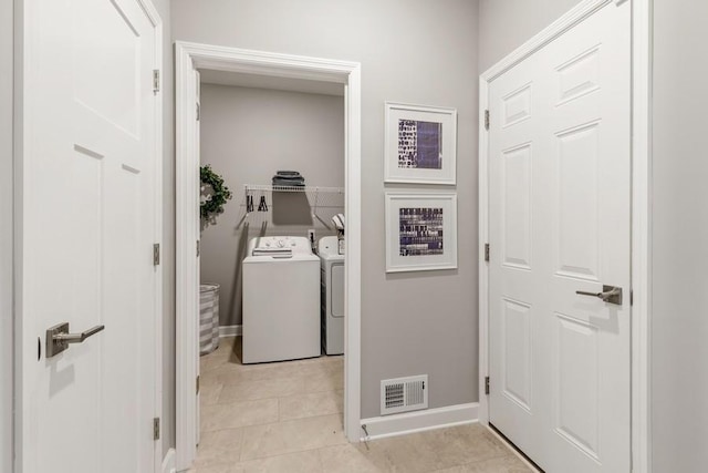 clothes washing area featuring washer and clothes dryer and light tile patterned flooring