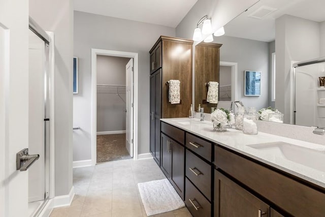 bathroom with tile patterned floors, vanity, and walk in shower