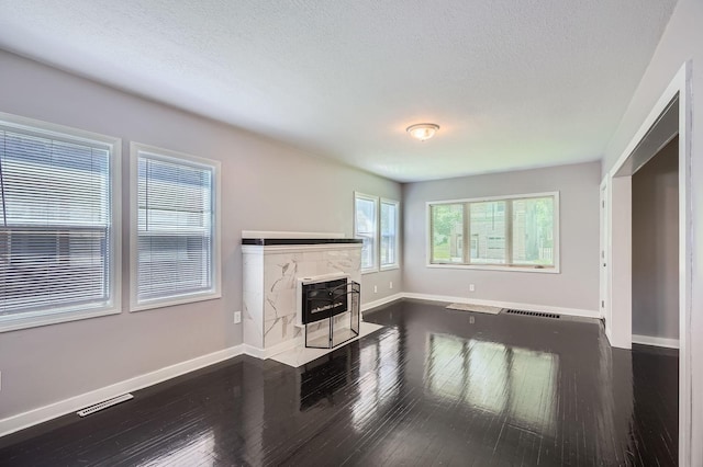 2810 Penn Ave N, Minneapolis, MN 55411 - unfurnished living room with dark wood-type flooring, a textured ceiling, and a fireplace