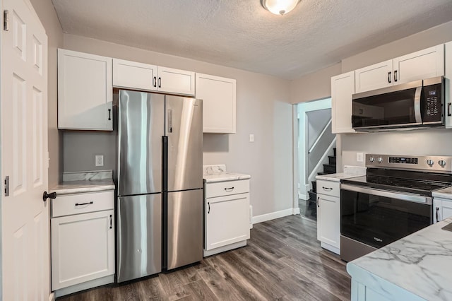 2810 Penn Ave N, Minneapolis, MN 55411 - kitchen featuring appliances with stainless steel finishes, white cabinets, dark wood-type flooring, light stone countertops, and a textured ceiling