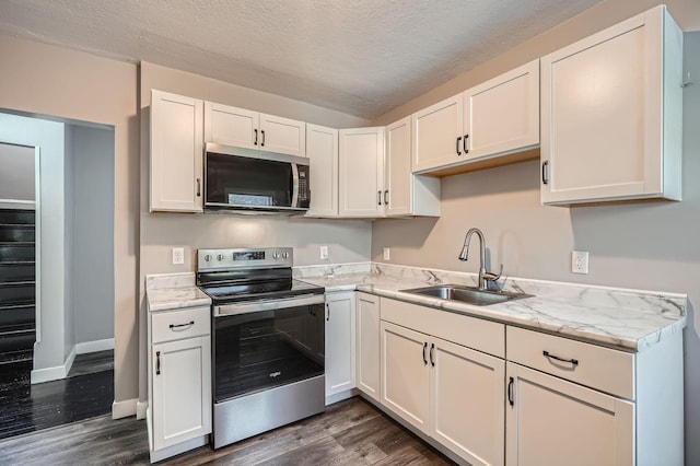 2810 Penn Ave N, Minneapolis, MN 55411 - kitchen with stainless steel appliances, dark wood-type flooring, white cabinets, and a textured ceiling