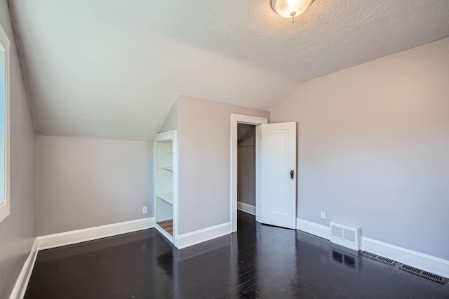 2810 Penn Ave N, Minneapolis, MN 55411 - unfurnished bedroom featuring lofted ceiling, wood finished floors, a textured ceiling, and a closet