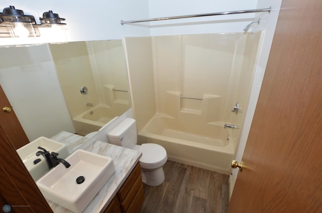 full bathroom featuring toilet, sink, washtub / shower combination, and hardwood / wood-style flooring