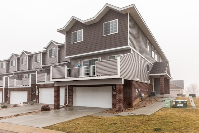 view of front of property with central AC unit, a garage, and a balcony