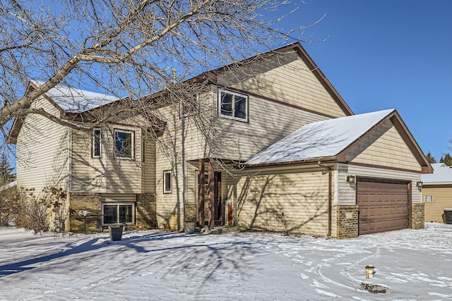 snow covered house with a garage