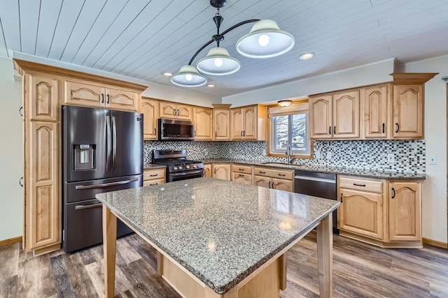 kitchen featuring dark stone countertops, stainless steel appliances, dark hardwood / wood-style flooring, pendant lighting, and a kitchen island