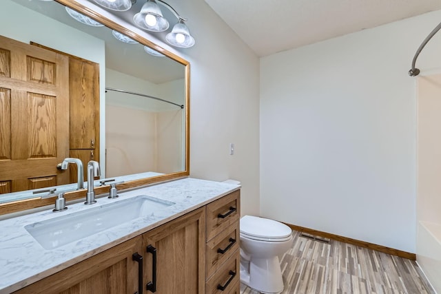 full bathroom featuring shower / bathtub combination, hardwood / wood-style flooring, vanity, and toilet