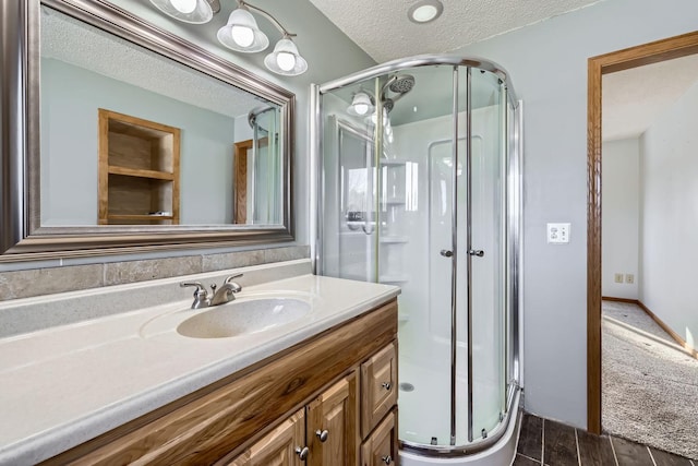 bathroom with an enclosed shower, a textured ceiling, and vanity