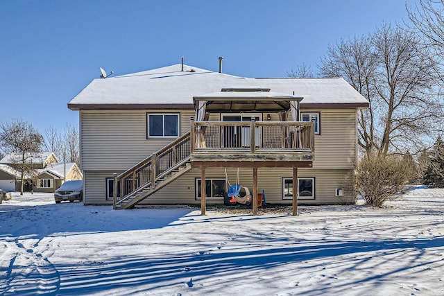 snow covered rear of property featuring a gazebo and a deck