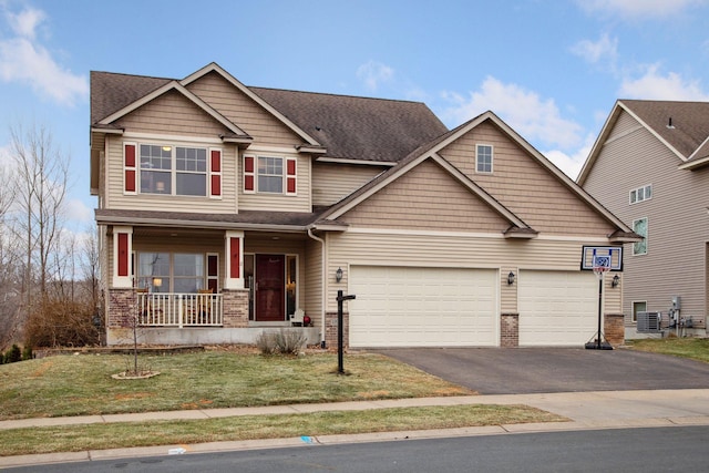 craftsman house with a porch, a garage, and a front lawn