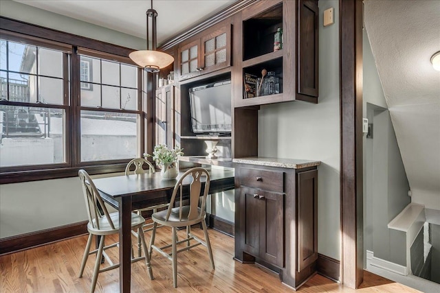 dining area with light wood-style flooring and baseboards