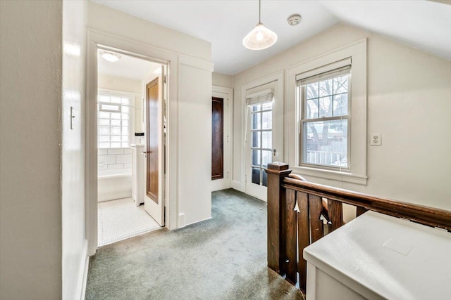 hallway featuring lofted ceiling and carpet floors