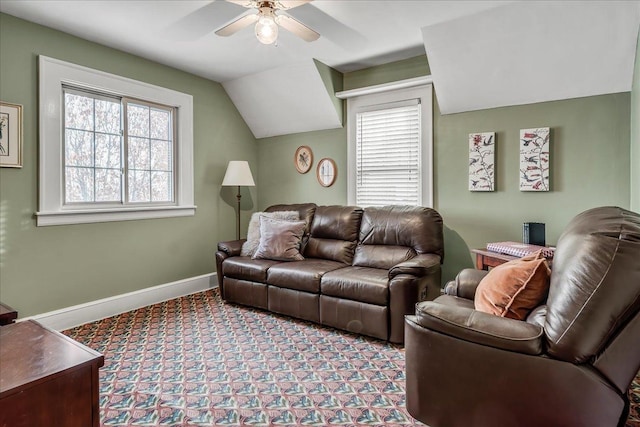 living area with baseboards, vaulted ceiling, and a ceiling fan