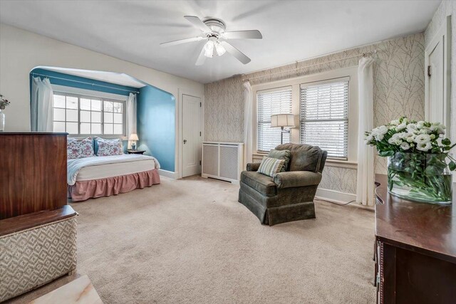 bedroom featuring baseboards, wallpapered walls, carpet, and radiator