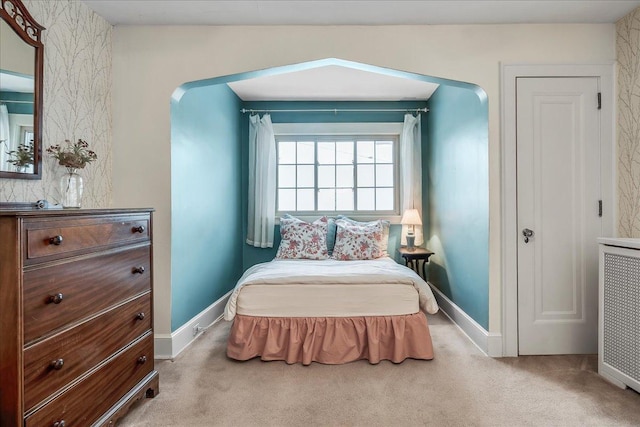 bedroom featuring arched walkways, carpet floors, and baseboards