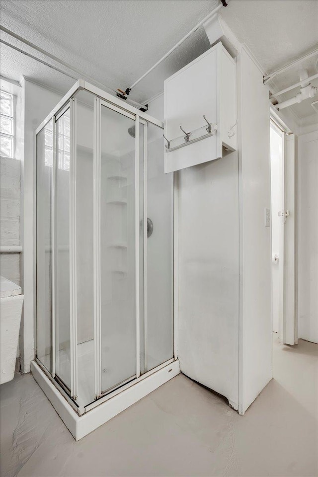 full bath featuring a stall shower and a textured ceiling