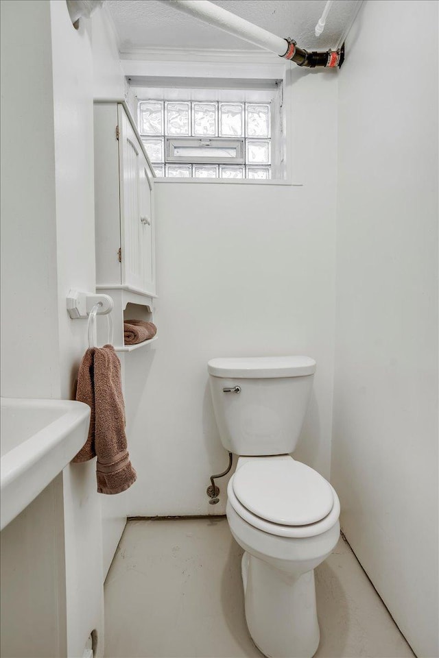 bathroom featuring concrete flooring and toilet