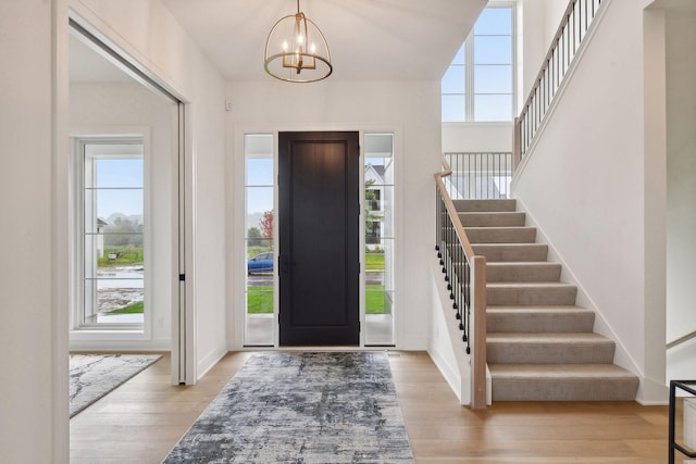 entryway featuring light wood-type flooring and a chandelier