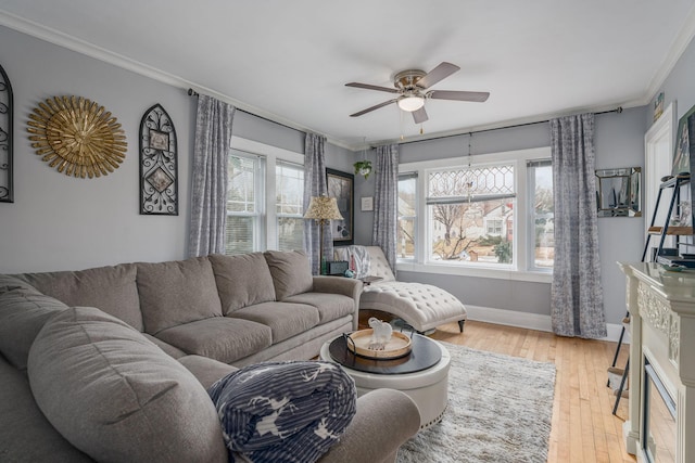 living room with crown molding, ceiling fan, plenty of natural light, and light hardwood / wood-style floors