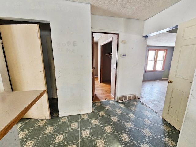 hallway with a textured ceiling