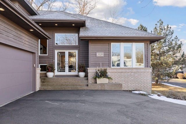 3529 Green Ridge Rd, Minnetonka, MN 55305 - property entrance featuring roof with shingles, french doors, driveway, and brick siding