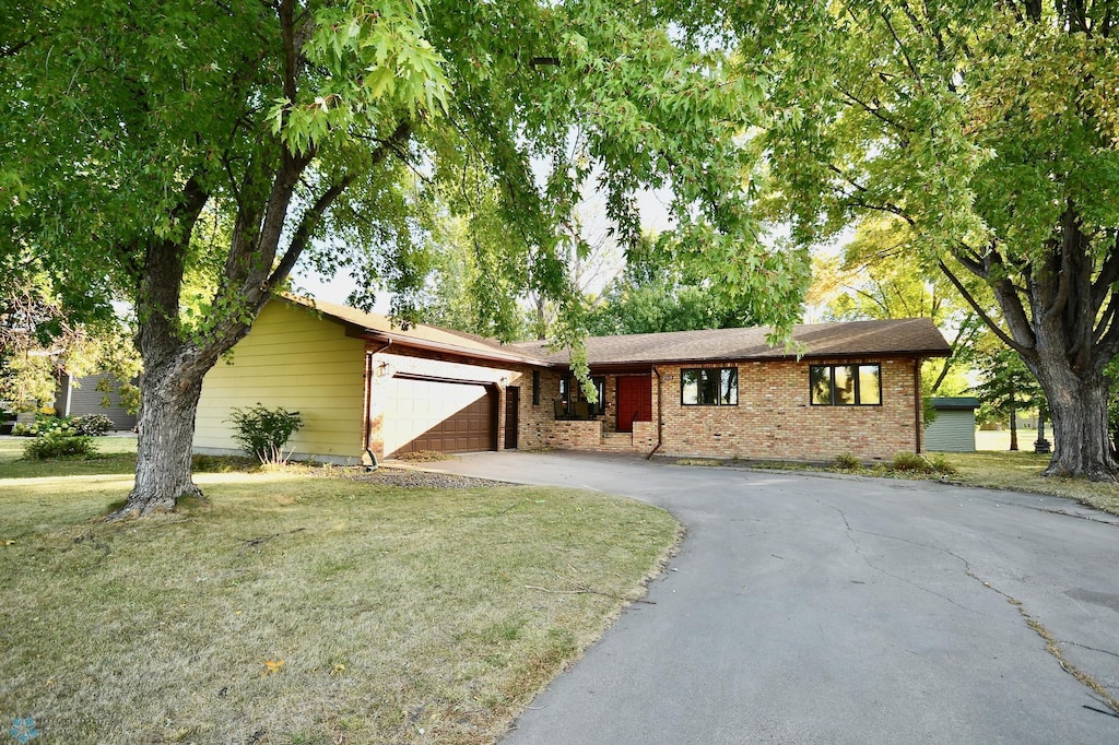 ranch-style house with a front yard and a garage