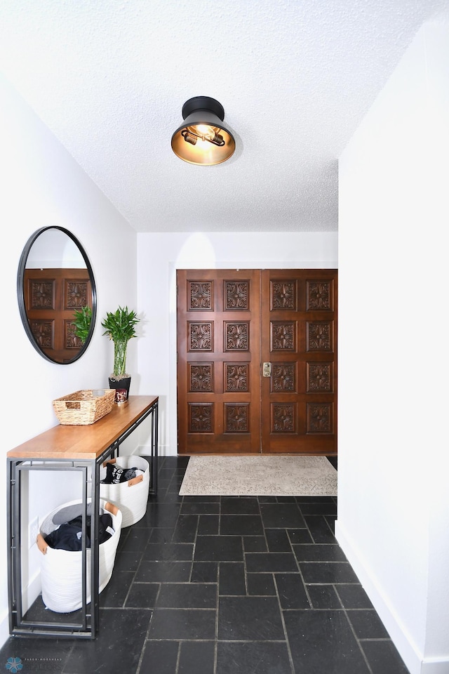 hall featuring a textured ceiling