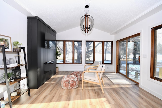 sunroom / solarium featuring a chandelier and vaulted ceiling