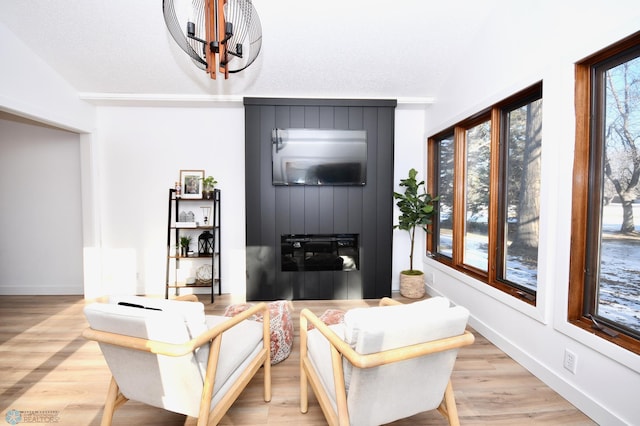 living room with light wood-type flooring, lofted ceiling, and a chandelier