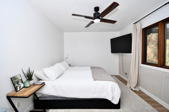 bedroom featuring ceiling fan, a textured ceiling, and hardwood / wood-style flooring