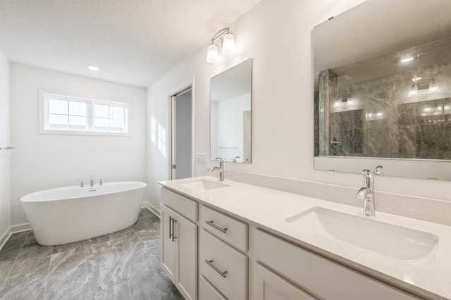 bathroom featuring a textured ceiling, vanity, and separate shower and tub