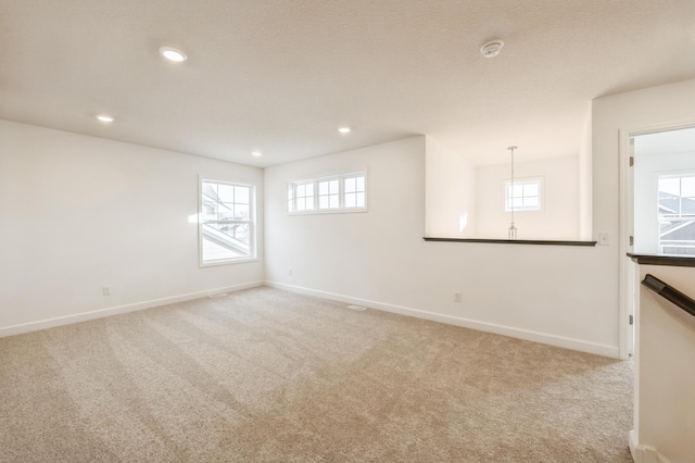 empty room with light carpet and plenty of natural light