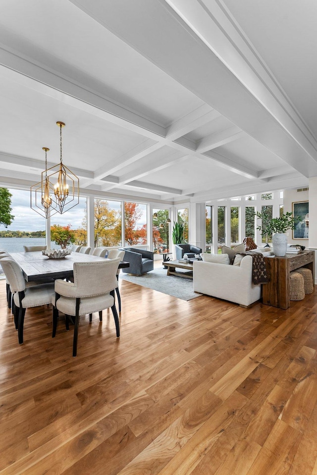 living room with coffered ceiling, hardwood / wood-style floors, a chandelier, and beamed ceiling