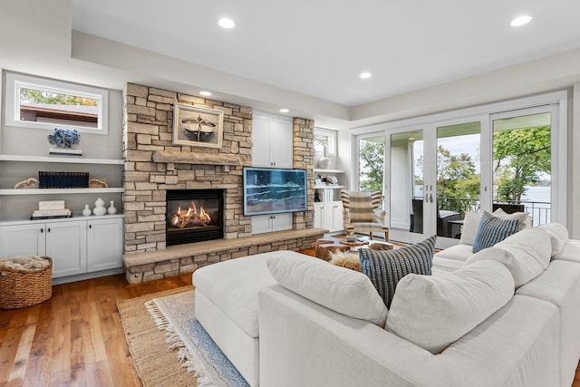 living room featuring a fireplace, light hardwood / wood-style floors, and french doors