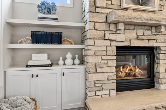 interior details featuring a stone fireplace and built in shelves