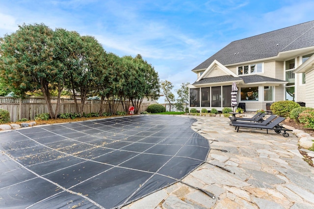 view of pool with a sunroom and a patio