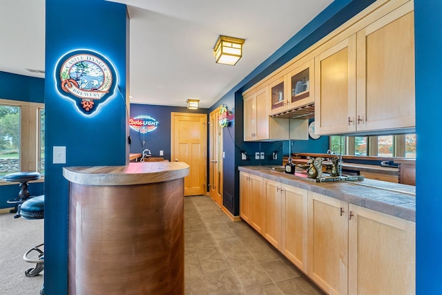 interior space with tile countertops, stainless steel gas cooktop, and light brown cabinets