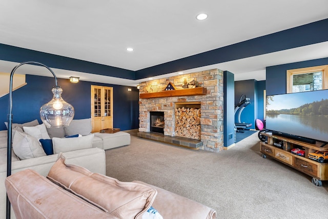 carpeted living room featuring a stone fireplace