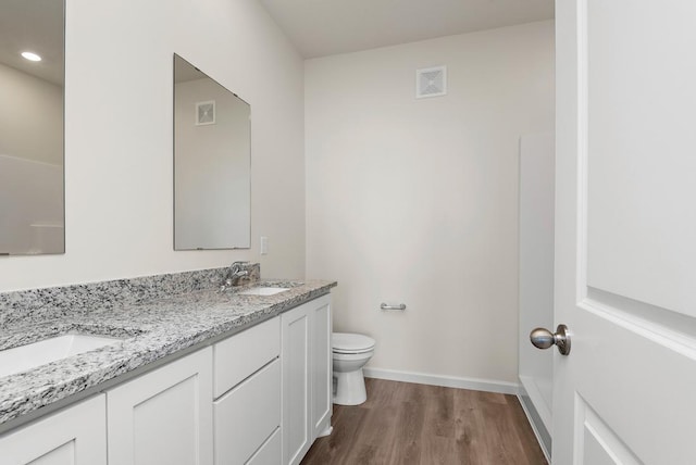 bathroom with vanity, hardwood / wood-style flooring, and toilet