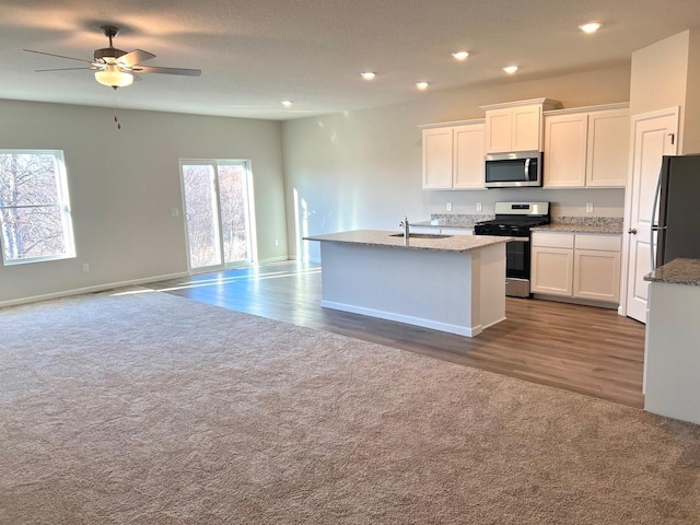 kitchen featuring a kitchen island with sink, white cabinetry, sink, and stainless steel appliances